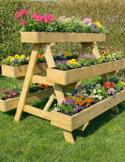 Moderne houten plantenbak met bloeiende planten en groenteplanten op een terras